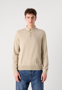 Polo shirt a maniche lunghe di un beige chiaro, realizzato in tessuto misto cotone, con colletto classico, patta con tre bottoni e polsini a costine con finitura senza cuciture.