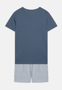 Dvojdielny outfit s modrým bavlneným topom s krátkym rukávom a pruhovanými modro-bielymi šortkami, ktorý má voľný strih a mäkkú textúru.