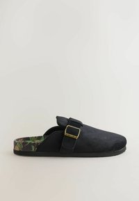 Sorte ruskinds slip-on sko med rund tå, justerbar spænde og indersål med blomstermønster. Tekstureret overflade med en flad gummisål.