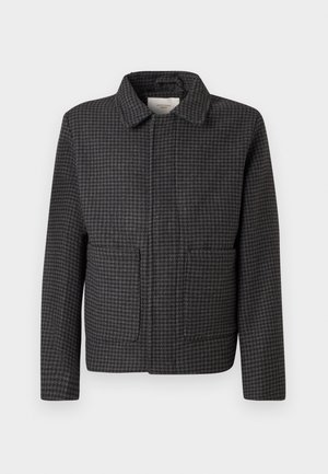 Chaqueta de cuadros gris con cuello, dos bolsillos frontales y corte recto. La tela es texturizada y presenta un clásico patrón de espiga.