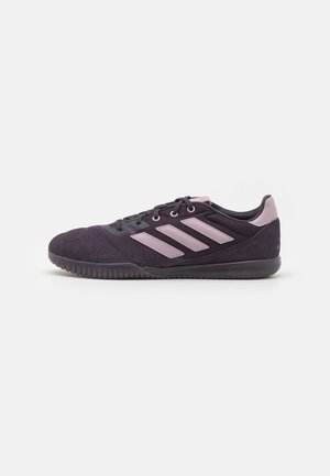 Baskets Adidas violet foncé avec des rayures, lacets et détails de talon violet clair, semelle en caoutchouc à profile bas, vue de côté sur fond blanc.