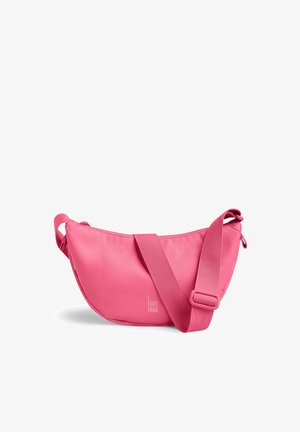 Sac bandoulière rose en forme de croissant, avec sangle réglable et fermeture éclair, doté d'un petit logo « GOT BAG » sur le devant.