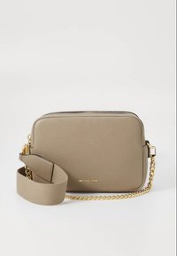 Beige leather crossbody bag with gold chain accent, rectangular shape, zipper closure, and adjustable fabric strap. Michael Kors branding visible.