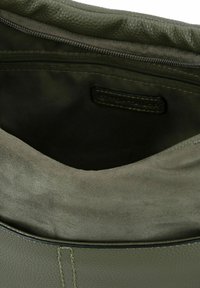 Bolso tote de cuero verde con una textura suave, que cuenta con un cierre con cremallera y un forro de tela suave. El interior presenta una etiqueta.