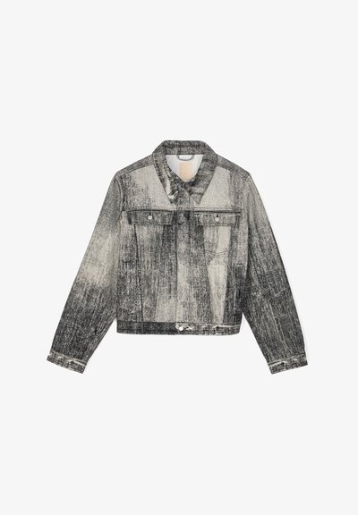 Chaqueta de mezclilla en blanco y negro con un patrón texturizado gráfico, dos bolsillos en el pecho, botones y un diseño corto.