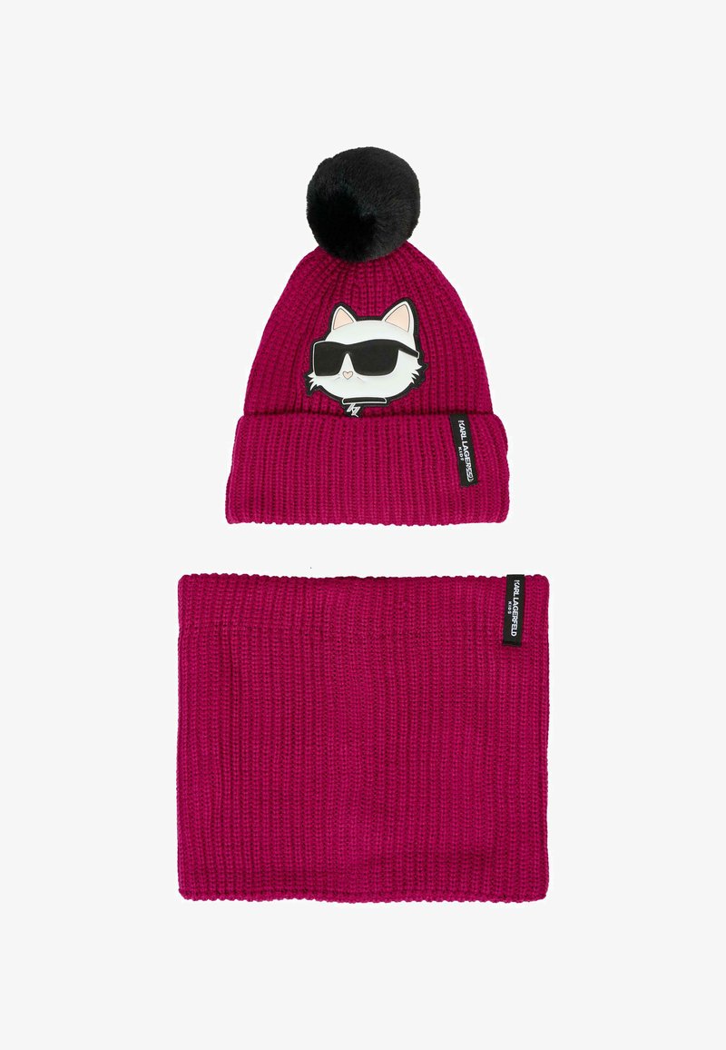 Berretto di maglia rosa scuro con pompon nero e patch di un gatto con occhiali da sole, abbinato a un caldo collettore per il collo di maglia rosa scuro.