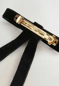 Black velvet suspenders with a gold metal clip. Features smooth texture, wide straps, and decorative hardware.