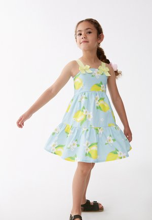 Vestido azul claro con estampado de limones y flores, corsé ajustado, falda acampanada y lazos dobles en las tirantes. Tela suave con volantes en capas.
