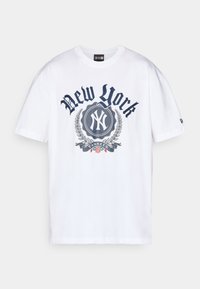 Camiseta blanca de algodón con un gráfico azul de "New York", logo circular con el símbolo "NY" y elementos florales decorativos debajo.