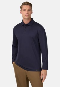 Polo a maniche lunghe di colore blu navy, realizzato in materiale morbido, con colletto classico, tre bottoni e un logo discreto sull'orlo.