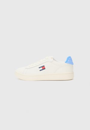 Hvit lær sneakers med blå aksent på hælen, logo-patch på siden og en teksturert gummisåle. Enkel og romslig design.