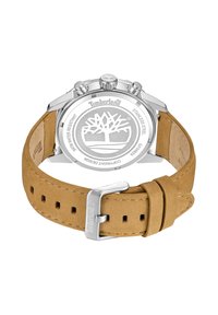 Reloj Timberland con caja de acero inoxidable plateada, correa de ante color marrón y logo grabado en la parte posterior que presenta un ícono de árbol.