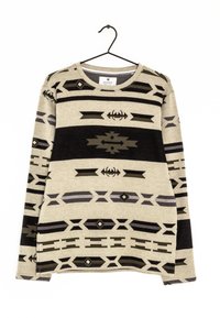 Beige Pullover mit langen Ärmeln und schwarzen sowie grauen geometrischen und tribal Muster, hängt an einem schwarzen Kleiderbügel vor einem weißen Hintergrund.