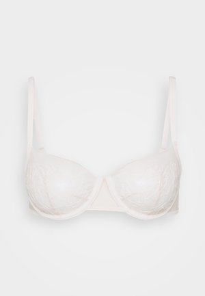 Bela nedrček z žico, ki ima prosojne skodelice s vezenimi cvetličnimi vzorci, nastavljive naramnice in gladek trak za oporo.