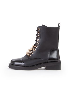 Botín negro de cuero con un acabado suave, que presenta ojales dorados redondos, adornos de rhinestones decorativos a lo largo de los cordones, y un tacón cuadrado.