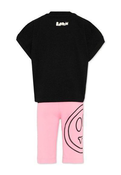 Chemise noire à manches courtes avec le texte « Barrow » au dos, associée à un short rose présentant un grand graphique de visage avec un contour noir sur une jambe.