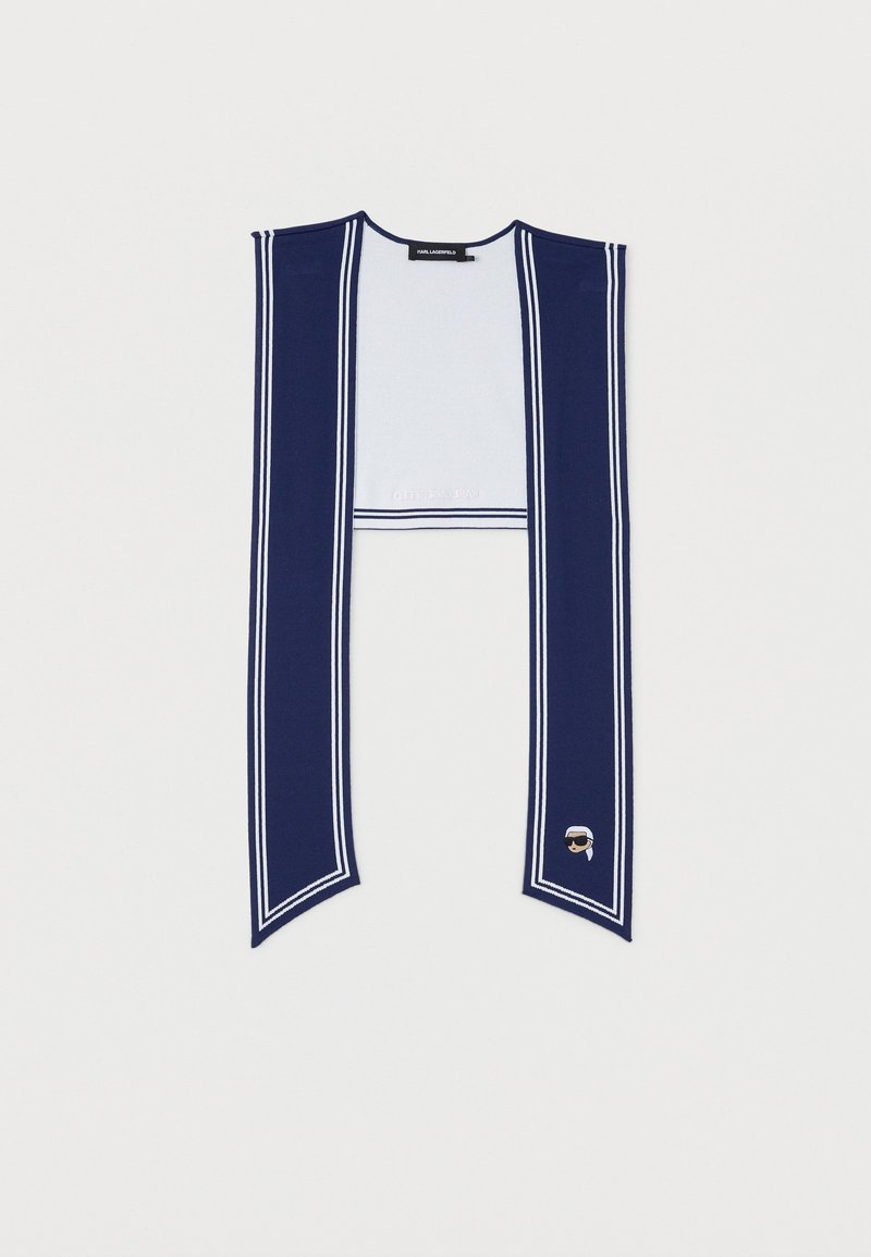 Μακρύ κασκόλ σε ναυτικό μπλε χρώμα με λευκές διπλές ρίγες κατά μήκος των άκρων και ένα μικρό κεντημένο πρόσωπο με γυαλιά ηλίου σε ένα άκρο.