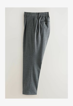 Pantalon à carreaux gris présenté sur un fond clair, doté d'une taille élastique et d'une poche arrière avec fermeture à bouton.