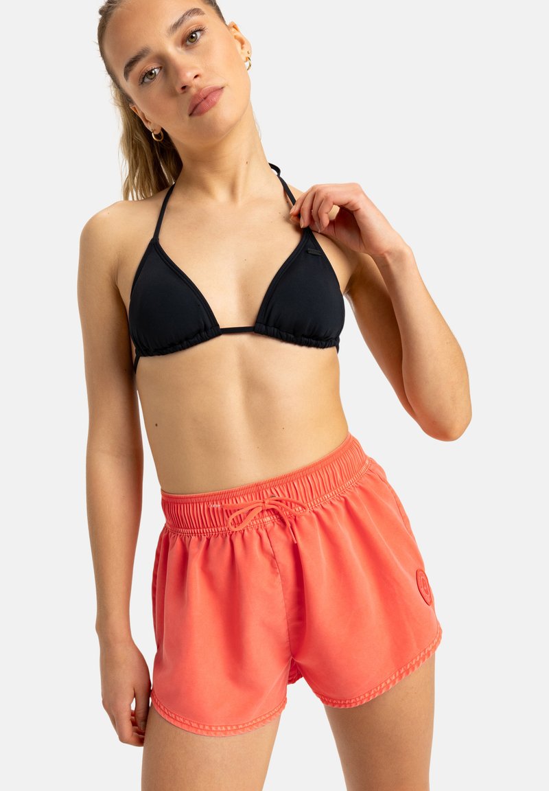 Schwarzer, dreieckiger Bikini-Oberteil kombiniert mit leuchtend korallenfarbenen Badeshorts, die über einen elastischen Bund und einen Kordelzug, eine glatte Textur und seitliche Taschen verfügen.