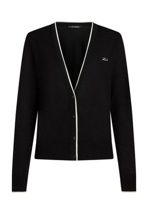 Cardigan negru cu nasturi și tiv alb de-a lungul decolteului și a manșetelor, cu mic broderie "Karl" pe pieptul stâng.