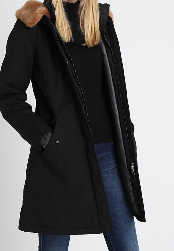 Czarny długi parka z kapturem wyłożonym futrem, z zapięciem na zamek z przodu i dwoma bocznymi kieszeniami. Wyłożony szarym materiałem, ma luźny krój i prosty fason.