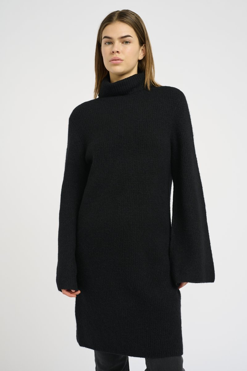 Maglione a collo alto lavorato a maglia di colore nero, con finitura testurizzata, maniche lunghe e vestibilità rilassata, che arriva fino a metà coscia.