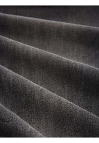 Tmavě šedá tkanina s měkkým, texturovaným povrchem, vykazující jemný tkaný vzor a hladký vlnkový efekt na záhybech.