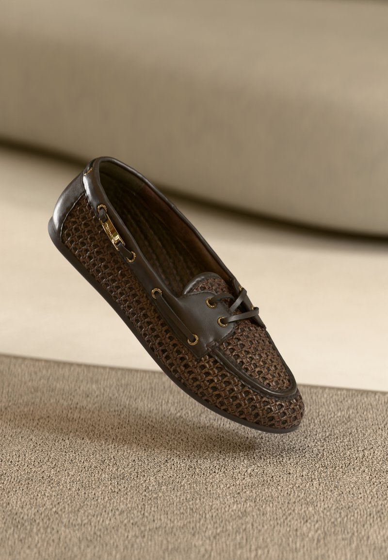 Chaussure bateau en cuir marron et textile tissé avec lacets et œillets dorés. Tige texturée et embout lisse.