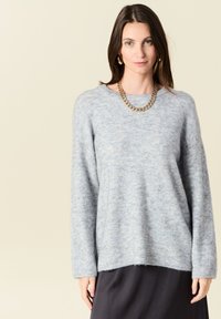 Maglione azzurro chiaro, morbido, con una vestibilità rilassata, scollatura rotonda e maniche lunghe. Presenta una texture soffice e orlo a coste.