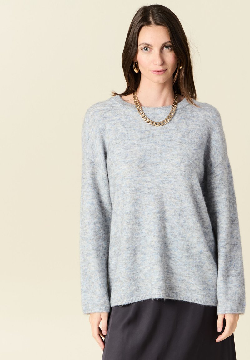 Maglione azzurro chiaro, morbido, con una vestibilità rilassata, scollatura rotonda e maniche lunghe. Presenta una texture soffice e orlo a coste.