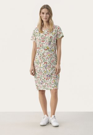 Rochie florală cu mâneci scurte și decolteu rotund, cu un fundal alb și modele florale multicolore. Purtați cu adidași albi.