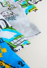 Tre T-shirt in tessuto di cotone: una grigia con grafiche, una bianca con stampe colorate e una blu con accenti e disegni gialli.