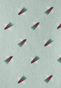 Tela verde claro con un patrón repetido de pequeños pájaros estilizados en rojo, negro y verde, con alas blancas y una textura suave.