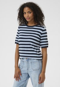 Top a maniche corte a righe in blu navy e azzurro chiaro, tessuto finemente lavorato, scollatura rotonda, design corto, indossato con jeans azzurri.