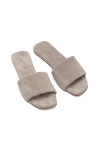 Infradito grigi in suede con una larga fascia imbottita e suole piatte. Texture morbida, design open-toe e stile minimalista.