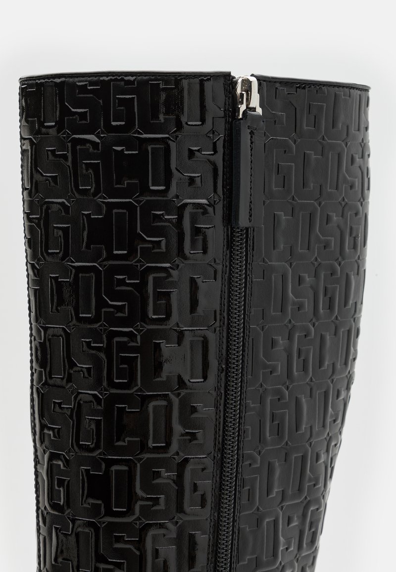 Schwarze kniehohe Stiefel mit einem glänzenden, geprägten Muster des Markennamens und einem seitlichen Reißverschluss zum Schließen. Texturierte, glatte Oberfläche.