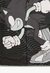 Sort stof med et grafisk billede af en hurtig blå ildrissel i hvid og grå. Karakterens design viser en dynamisk bevægelse med stiliserede linjer.