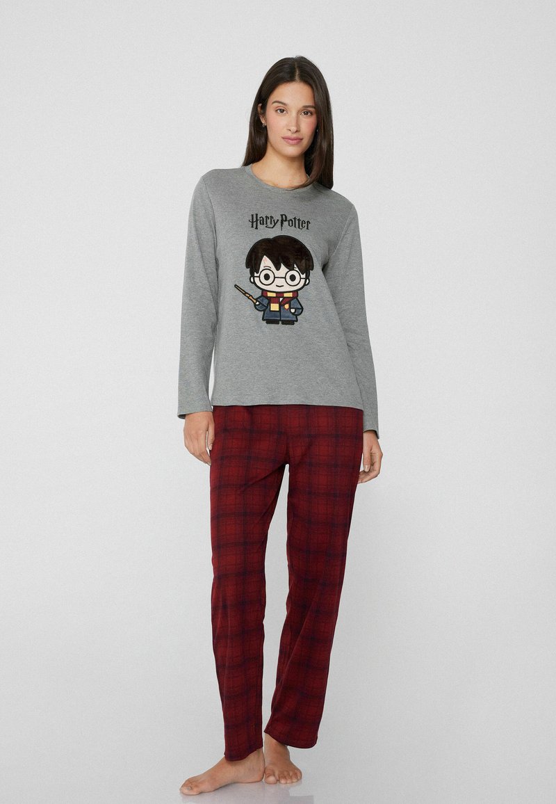 Camiseta de pijama de manga larga gris con un gráfico de Harry Potter. Combinada con pantalones de pijama de cuadros rojos y negros, de tejido suave y corte relajado.