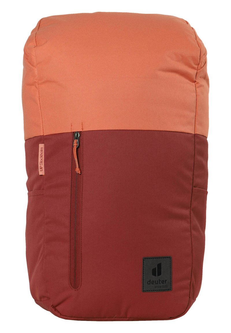 Mochila roja y naranja con una parte superior acolchada, bolsillo con cremallera en el lateral y una sección inferior texturizada. Presenta un logotipo de la marca en la parte frontal.