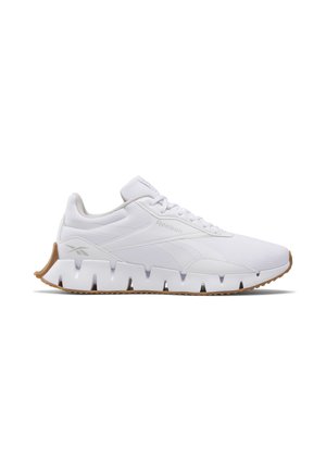 Zapatilla deportiva blanca con parte superior de malla, cuello acolchado y suela de goma texturizada con detalles recortados. Suela marrón para tracción.