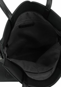 Sac fourre-tout noir avec tissu texturé, poignées en cuir, poche intérieure zippée et intérieur spacieux en noir. Design minimaliste sans logos visibles.