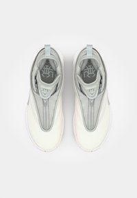 Lys grå og hvide sneakers med en lynlåsdækning, glat tekstur og rund tå. Har en blød indersål og mønstret indlægssål.