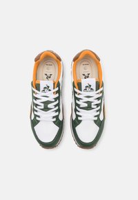 Baskets verts, blancs et orange en matériaux cuir et textile. Présentent des lacets blancs, un col rembourré et un logo sur la languette. Semelle extérieure en caoutchouc.
