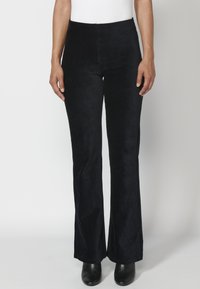 Zwarte fluwelen wijde broek met een hoge taille, met een gladde textuur en een aansluitende silhouet, gedragen met enkellaarsjes.