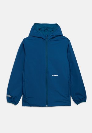 Μπλε μπουφάν με κουκούλα, μπροστινό φερμουάρ, ελαστικά μανίκια και μικρό λευκό λογότυπο "core" στο στήθος και στο μανίκι, σε απλό φόντο.