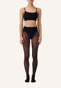 Bralette nero senza cuciture e collant trasparenti a vita alta. Tessuto morbido con un design aderente. Vita elastica e spalline minime.
