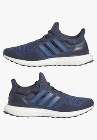 Sapatilhas desportivas azul-marinho com parte superior em malha respirável, três riscas assinatura e uma sola branca almofadada que exibe em destaque "Ultra Boost."