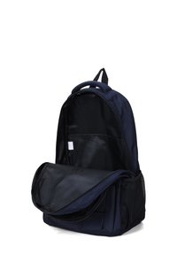 Sac à dos bleu marine avec un compartiment principal zippé, une poche latérale en mesh et une poignée rembourrée. L'intérieur présente une doublure noire et une poche d'organisation.