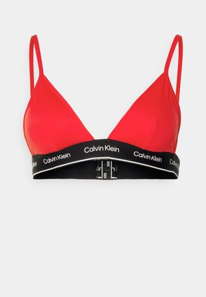 Červený trojuholníkový bralet s tenkými ramienkami, čierny elastický pás so značkovaním "Calvin Klein" a zapínaním na prednej strane.