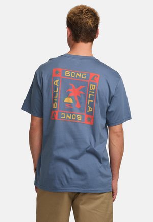 Camiseta de algodón azul con un gráfico colorido de palmeras y olas en la parte posterior, enmarcado por un diseño de borde rectangular.
